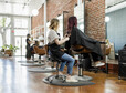 Hairstylist trimming hair of the customer in a beauty salon
