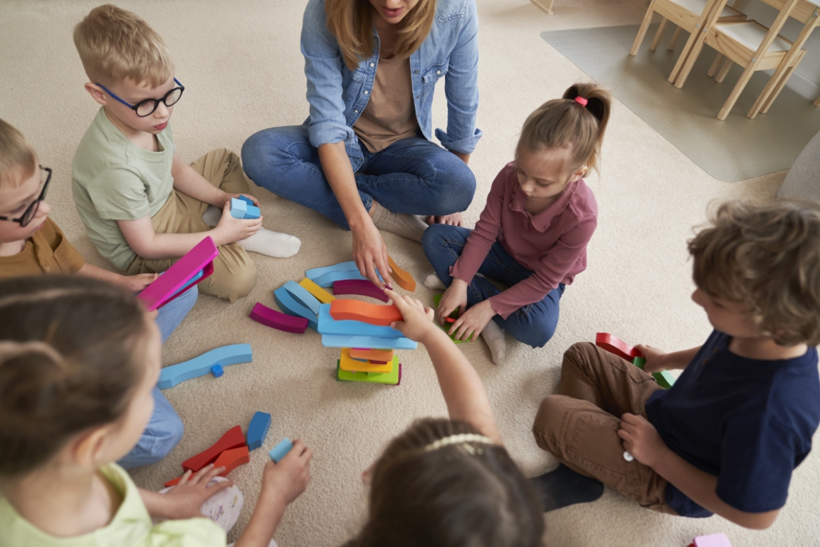 Top view of children playing with toy blocks