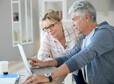 Senior couple at home checking expenses on internet
