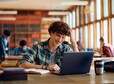 Happy student using laptop while learning during a class at high school. 